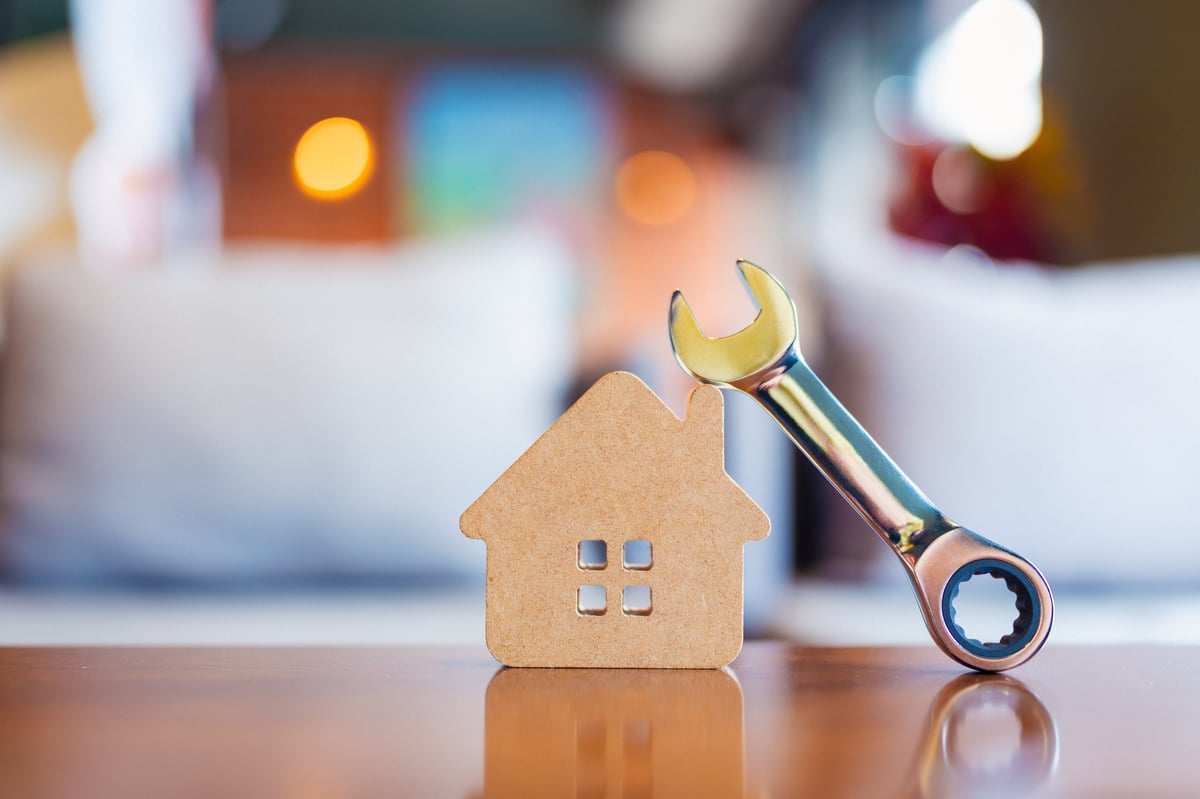 Model house beside a wrench representing friendly home repair services